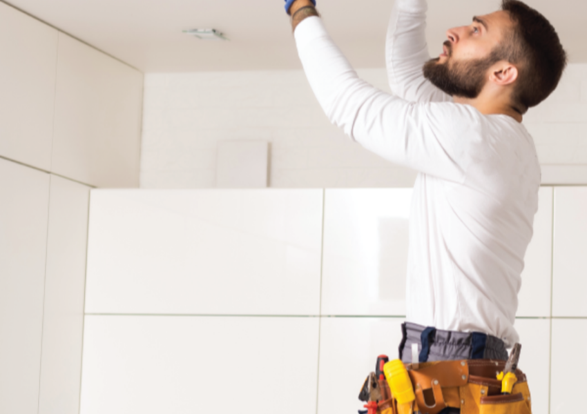 Person fixing a light on the ceiling