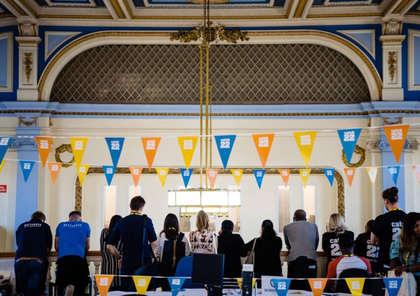 People standing in a line looking at a wall at a Catch22 event